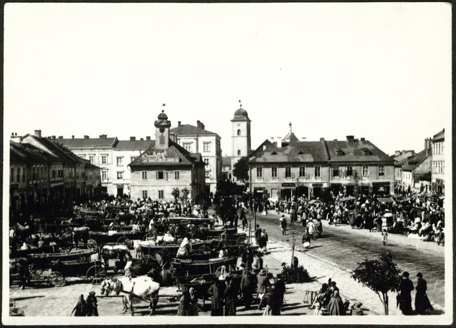 Edward Janusz (Rzeszów) – RYNEK w dzień targowy (tłum, furmanki, stragany), fotografia [scena rodzajowa – widok miasta]