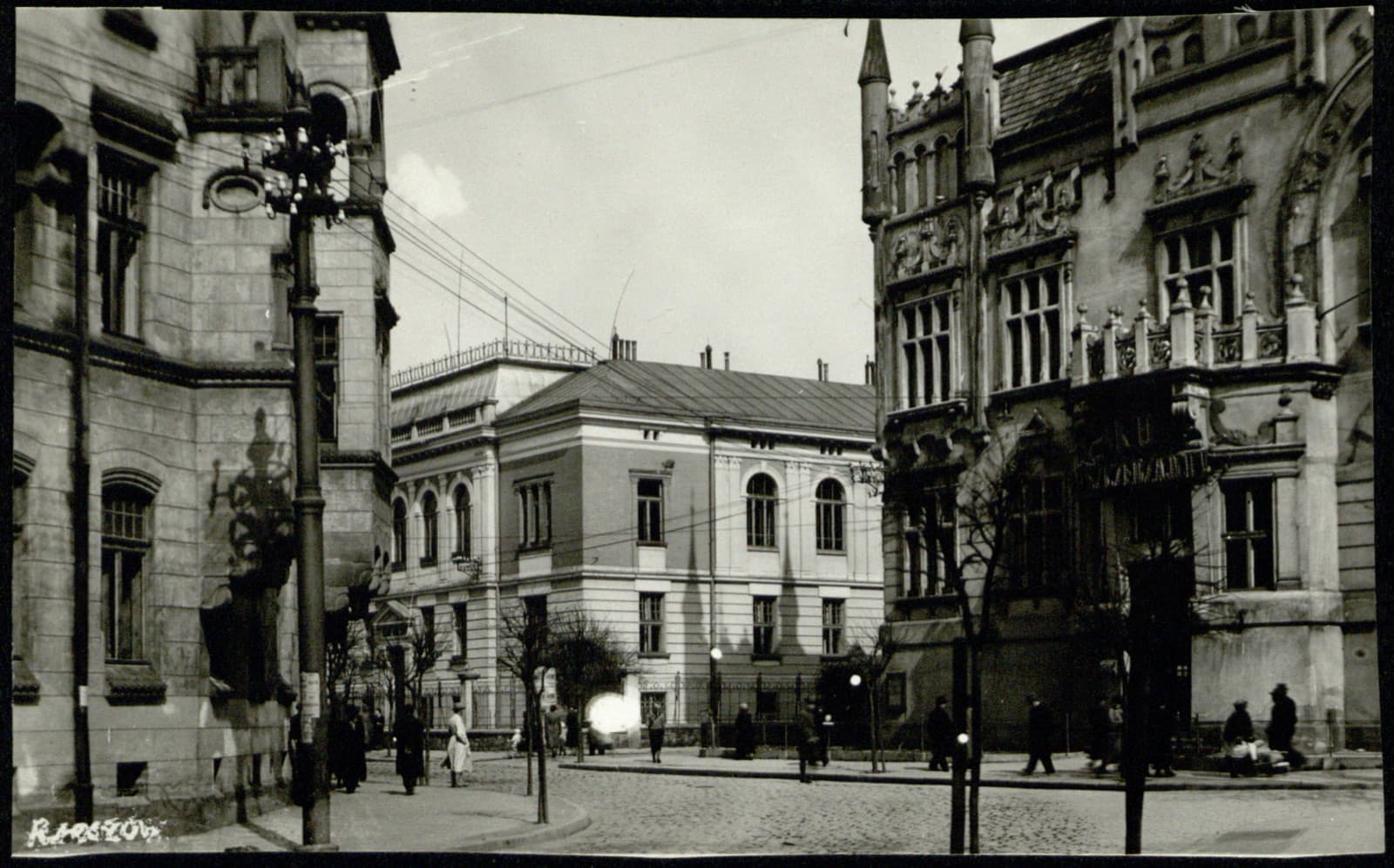Edward Janusz (Rzeszów) – ulica z okazałym gmachem (prawdop. Kasa Oszczędności), scena uliczna, pocztówka fotograficzna