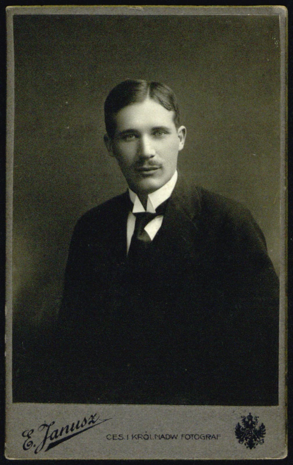 Edward Janusz (Rzeszów) – portret młodego mężczyzny w garniturze i muszce (archiwum rodziny Januszów), fotografia [pełna pieczątka atelier]