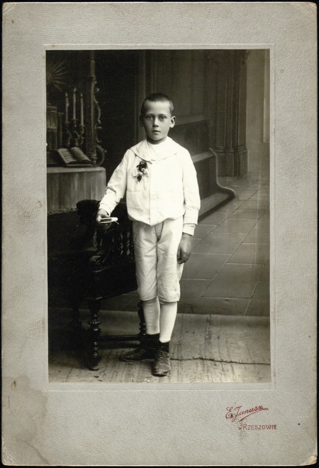 Edward Janusz (Rzeszów) – portret chłopca w stroju do I Komunii ze świecą (album rodzinny Januszów), fotografia gabinetowa